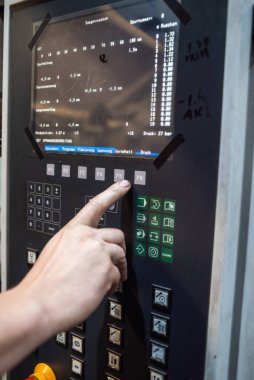 Fabrikanın üretimi için makineyi kullanan işçiler.