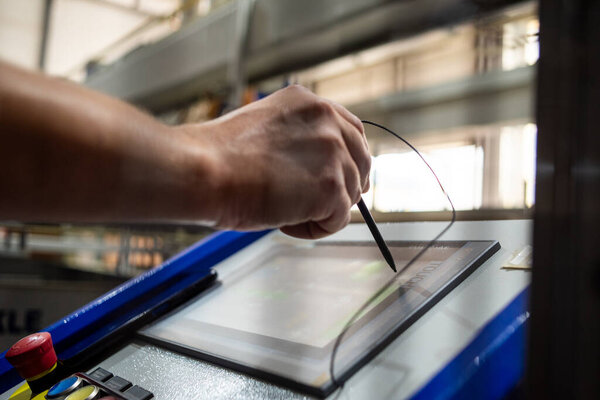 the hand of worker with a tablet in factory, the production process