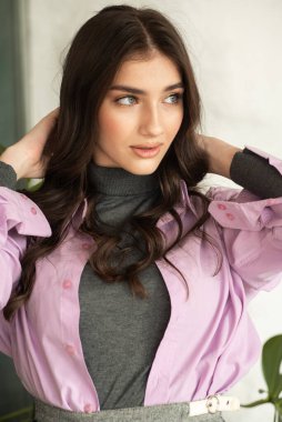 Stüdyoda poz veren uzun saçlı genç bir kadın.