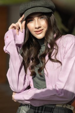 Genç Asyalı kadın güzel bir elbise ve şapka giyiyor.