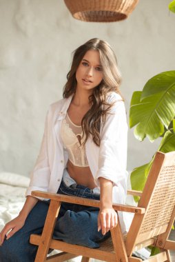 Balkonda beyaz bluzlu ve kot şortlu güzel bir kız..