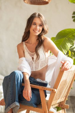 Beyaz bluz ve kot giyen genç bir kadın.