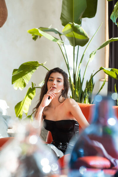 young beautiful girl in a black jacket and a white shirt sitting at a cafe in a restaurant.