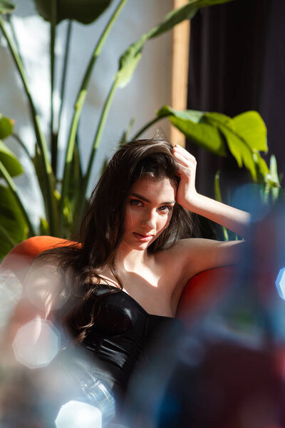 young woman sitting on sofa with glass of water at home