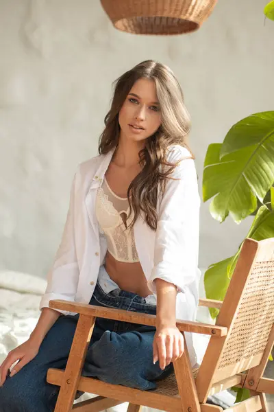 Balkonda beyaz bluzlu ve kot şortlu güzel bir kız..