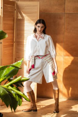 Beyaz gömlekli güzel esmer ve şakayık desenli kırmızı etekli.