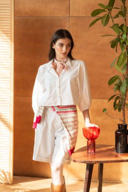 Stüdyoda güzellik, moda ve moda tarzında poz veren uzun esmer saçlı güzel bir genç kadın.