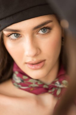 Şapkalı, genç ve güzel bir kadın. Gözleri kapalı.