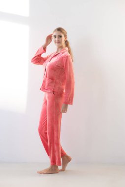 Açık arkaplanda açık gri elbisesi olan pembe elbiseli güzel bir kadın.