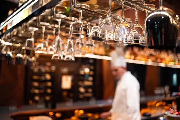 Barmen şişeden bardağa taze alkollü içecek dolduruyor.