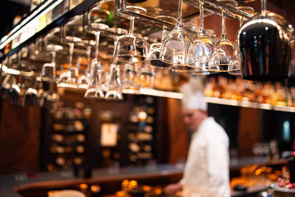bartender pouring fresh alcoholic beverage from bottle into glass