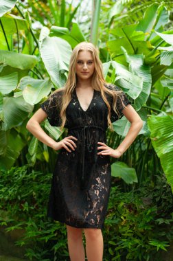 Tropik tatil köyünde yazlık giysiler giyen güzel genç bir kadın.