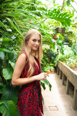 Tropik tatil köyünde yazlık giysiler giyen güzel genç bir kadın.