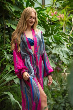 Tropik tatil köyünde yazlık giysiler giyen güzel genç bir kadın.