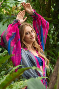 Tropik tatil köyünde yazlık giysiler giyen güzel genç bir kadın.