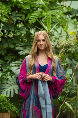 Tropik tatil köyünde yazlık giysiler giyen güzel genç bir kadın.