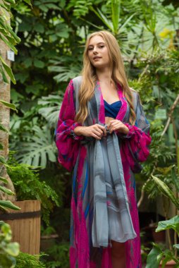 Tropik tatil köyünde yazlık giysiler giyen güzel genç bir kadın.