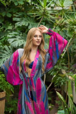 Tropik tatil köyünde yaz kıyafetleri giyen bir kadın.