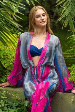 Tropik tatil köyünde yaz kıyafetleri giyen bir kadın.