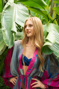 Tropik tatil köyünde yaz kıyafetleri giyen bir kadın.