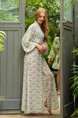 Tropik tatil köyünde yaz kıyafetleri giyen bir kadın.