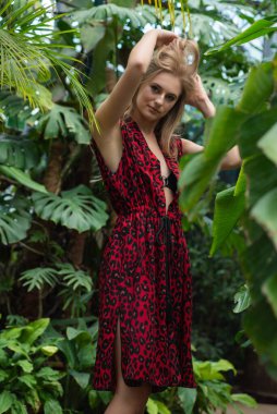 Tropik tatil köyünde yaz kıyafetleri giyen bir kadın.