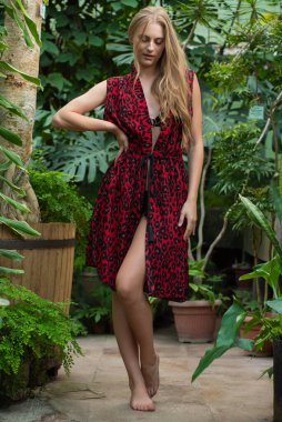 Tropik tatil köyünde yaz kıyafetleri giyen bir kadın.