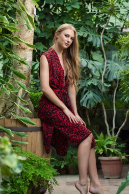 Tropik tatil köyünde yaz kıyafetleri giyen bir kadın.