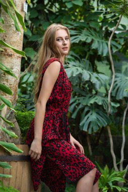 Tropik tatil köyünde yaz kıyafetleri giyen bir kadın.