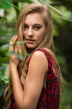 Tropik tatil köyünde yaz kıyafetleri giyen bir kadın.