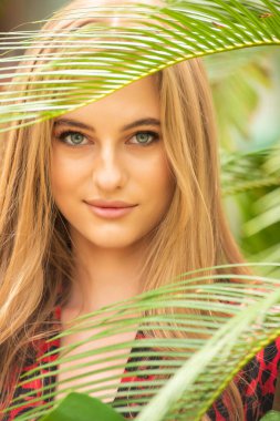 Tropik tatil köyünde yaz kıyafetleri giyen bir kadın.