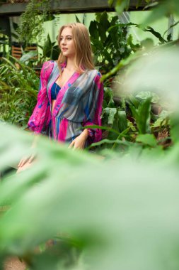 Tropik tatil köyünde yaz kıyafetleri giyen bir kadın.