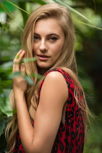 Tropik tatil köyünde yaz kıyafetleri giyen bir kadın.