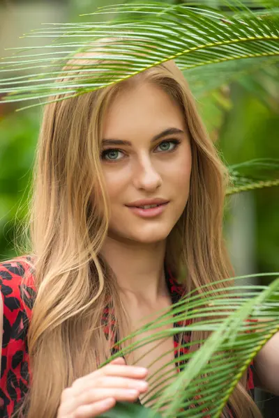 Tropik tatil köyünde yaz kıyafetleri giyen bir kadın.