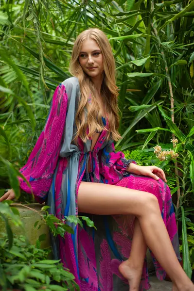 Tropik tatil köyünde yaz kıyafetleri giyen bir kadın.