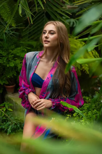 Tropik tatil köyünde yaz kıyafetleri giyen bir kadın.