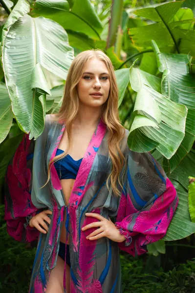 Tropik tatil köyünde yaz kıyafetleri giyen bir kadın.