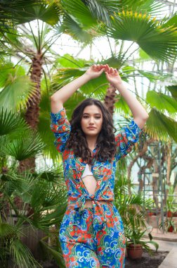 Tropik tatil köyünde yazlık giysiler giyen güzel genç bir kadın.