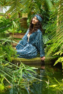 Tropik tatil köyünde yaz kıyafetleri giyen bir kadın.