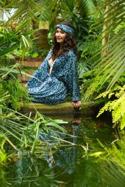 Tropik tatil köyünde yaz kıyafetleri giyen bir kadın.