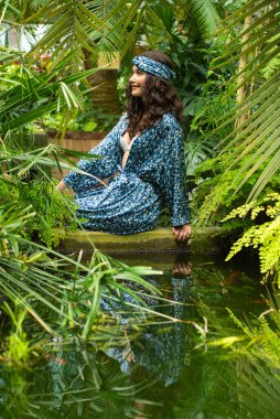 Tropik tatil köyünde yaz kıyafetleri giyen bir kadın.
