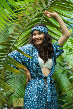 Tropik tatil köyünde yaz kıyafetleri giyen bir kadın.