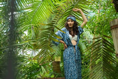 Tropik tatil köyünde yaz kıyafetleri giyen bir kadın.