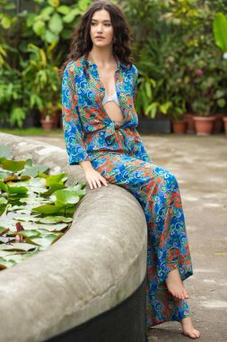 Tropik tatil köyünde yaz kıyafetleri giyen bir kadın.