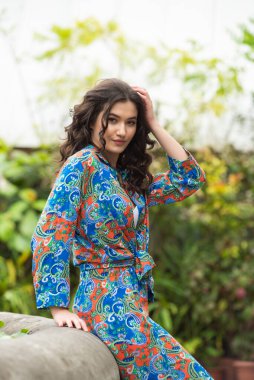 Tropik tatil köyünde yaz kıyafetleri giyen bir kadın.