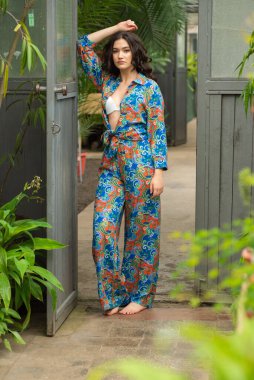 Tropik tatil köyünde yaz kıyafetleri giyen bir kadın.