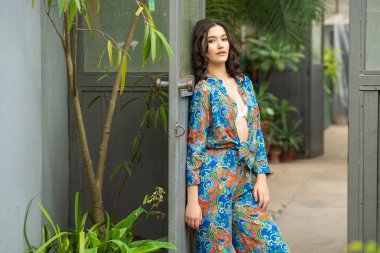 Tropik tatil köyünde yaz kıyafetleri giyen bir kadın.