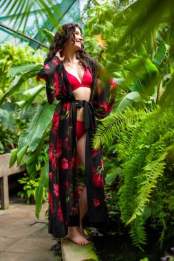 Tropik tatil köyünde yaz kıyafetleri giyen bir kadın.