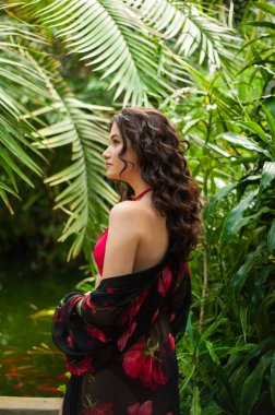 Tropik tatil köyünde yaz kıyafetleri giyen bir kadın.