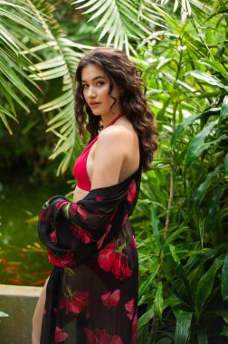 Tropik tatil köyünde yaz kıyafetleri giyen bir kadın.